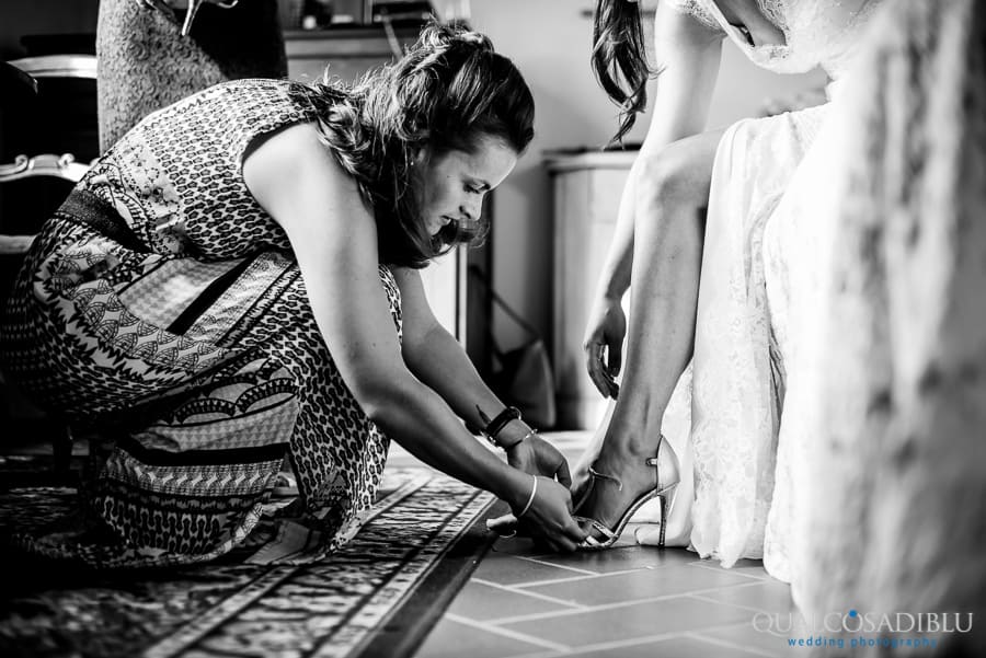 sister of the bride putting the wedding shoes