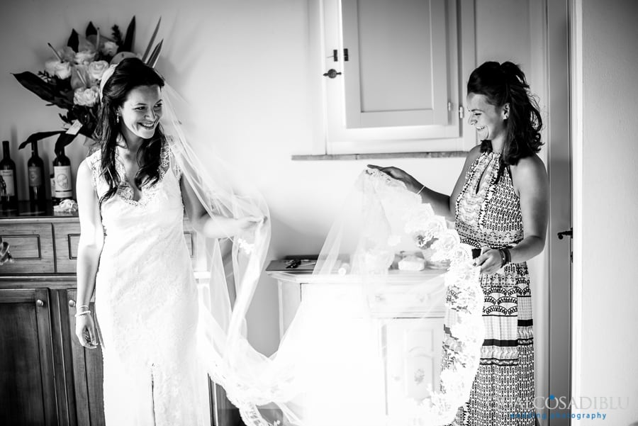 bride smiling holding the log white veil