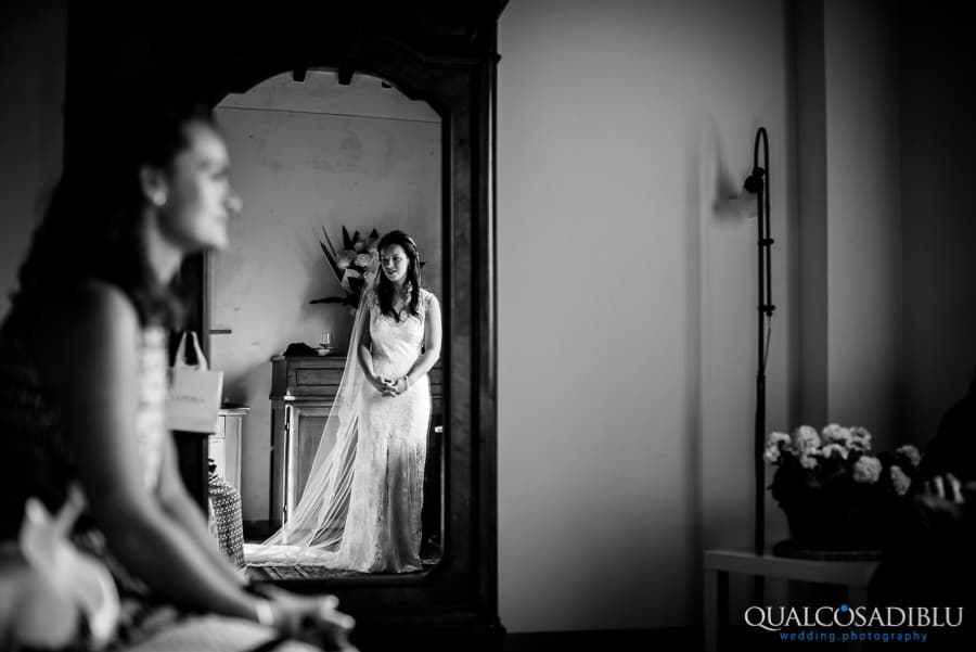 bride with white dress at mirror black and white