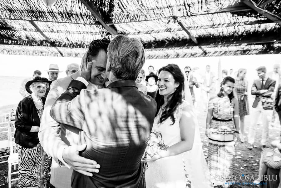 father of the bride kissing the groom in the forehead