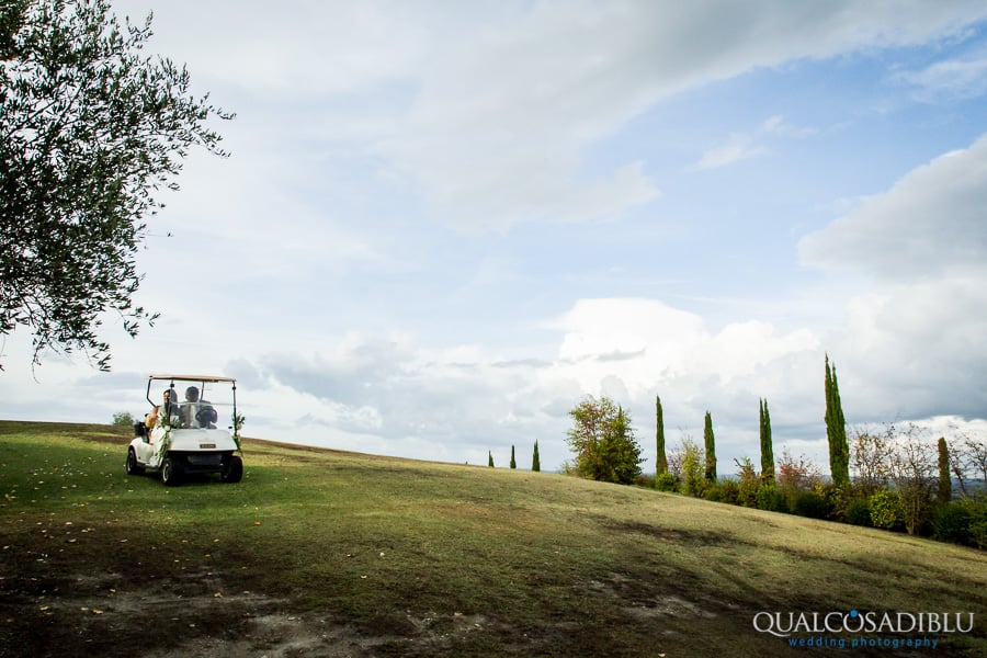 bride and groom in the golf car together borgo della meliana