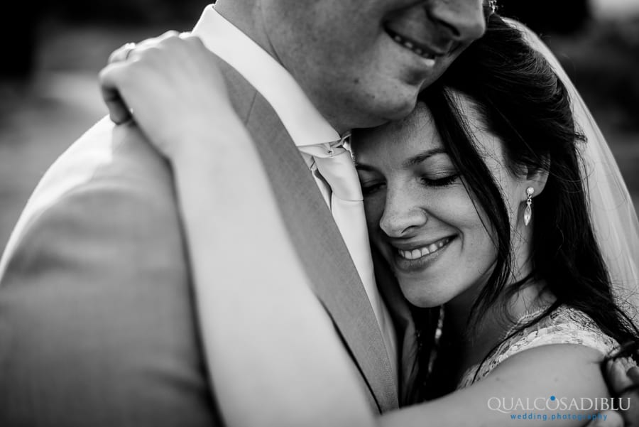 bride and groom smiling ambraced together black and white