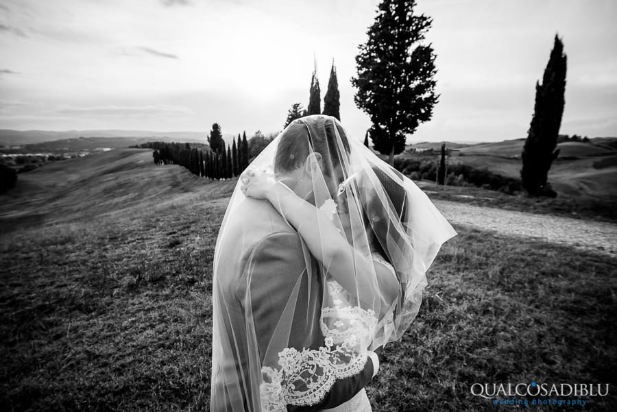 bride and groom embraced under the veil tuscany hills black and white