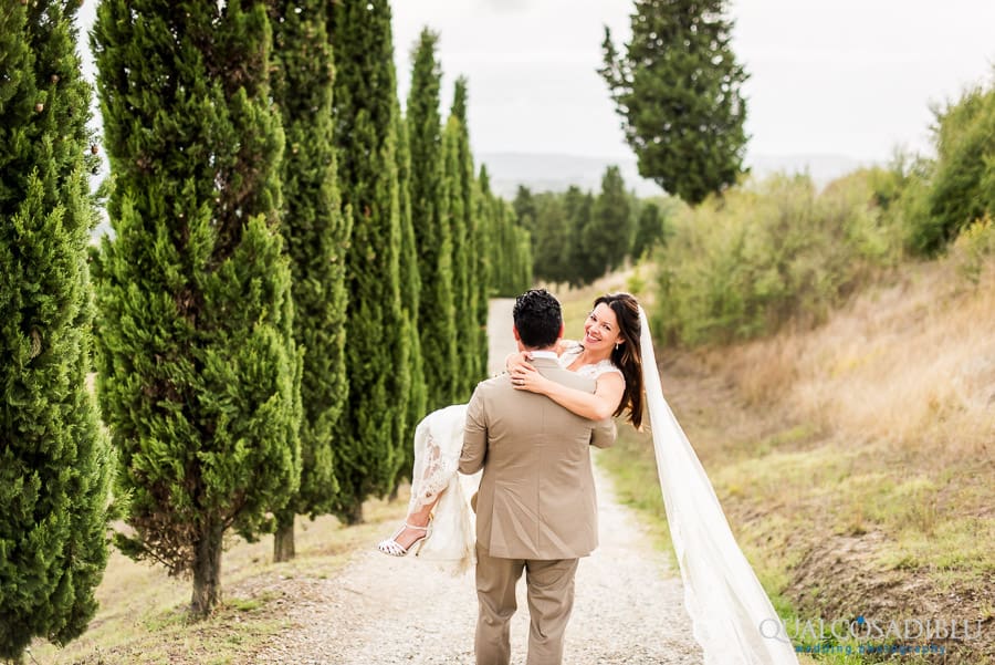 groom holding the bride smiling in his arms