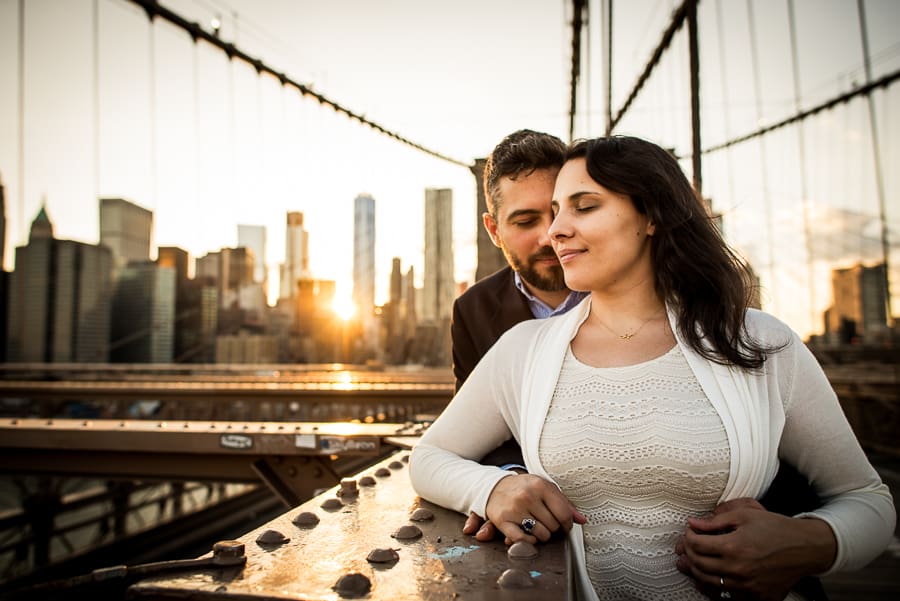 Couple embraced on brooklyn bridge and sylines in the background