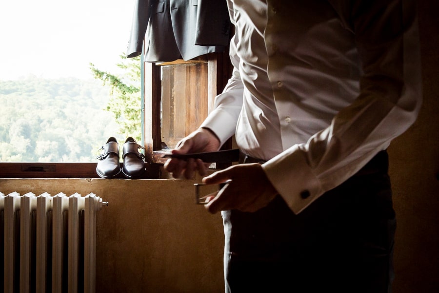 groom wearing belt getting ready