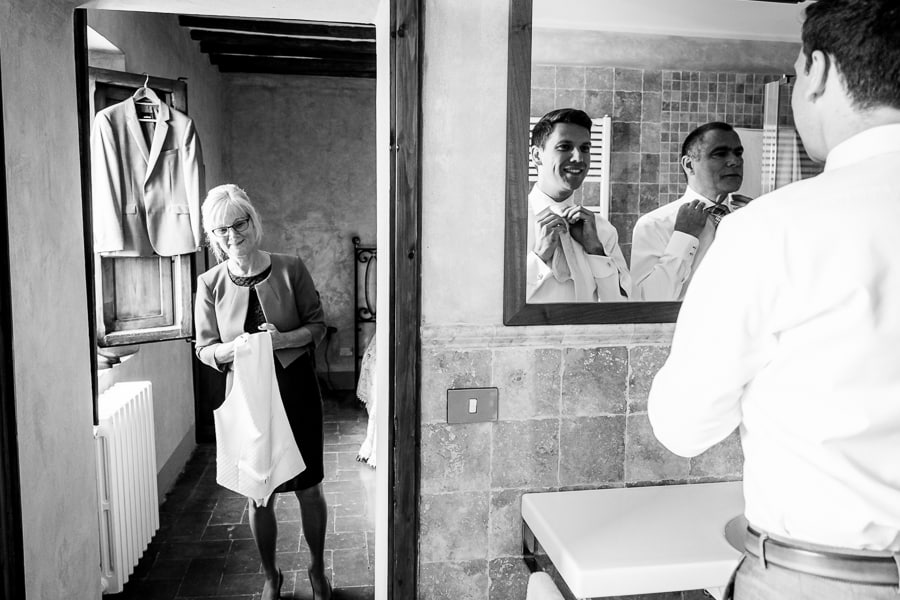 groom at mirror with parents