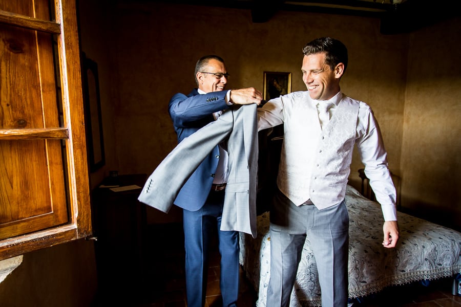 groom dressing the jacket with his father