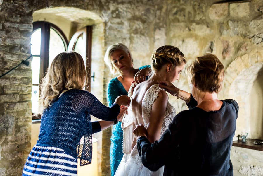 mother of the bride helping wearing the wedding dress