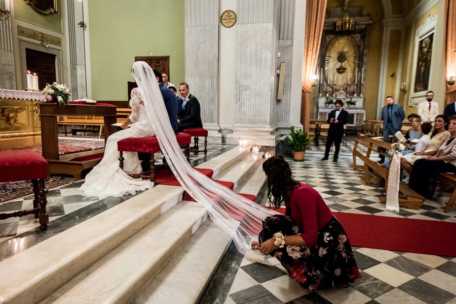 braidsmaid adjusting veil to the bride church
