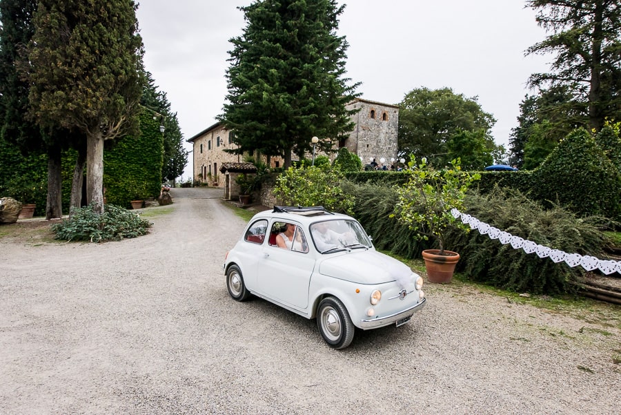 wedding couple arrives at fattoria di larniano fiat 500