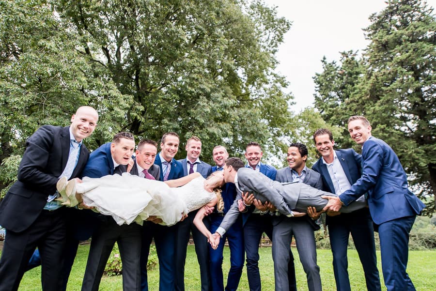 group photo bride groom kissing hold by the friends