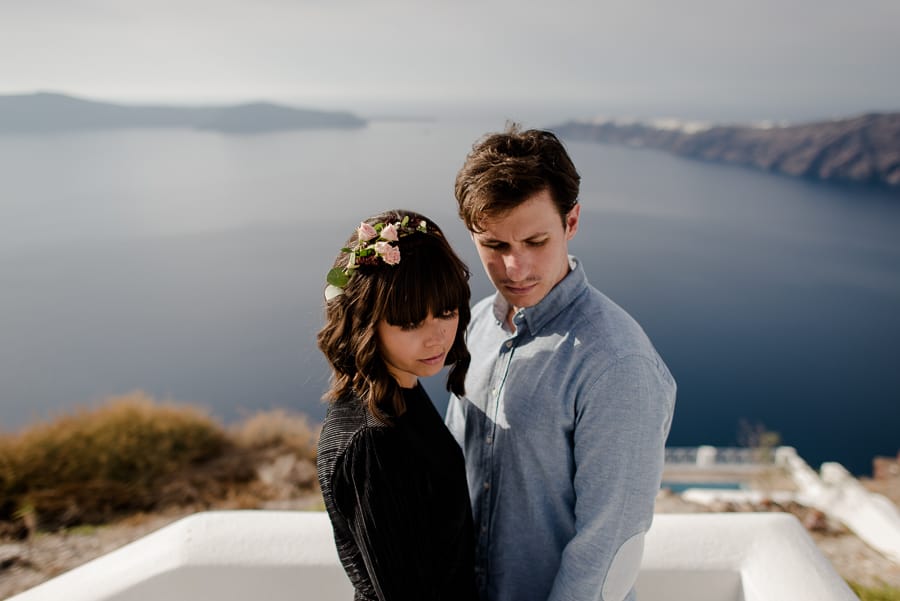 couple engaged in santorini with amazing view of caldera