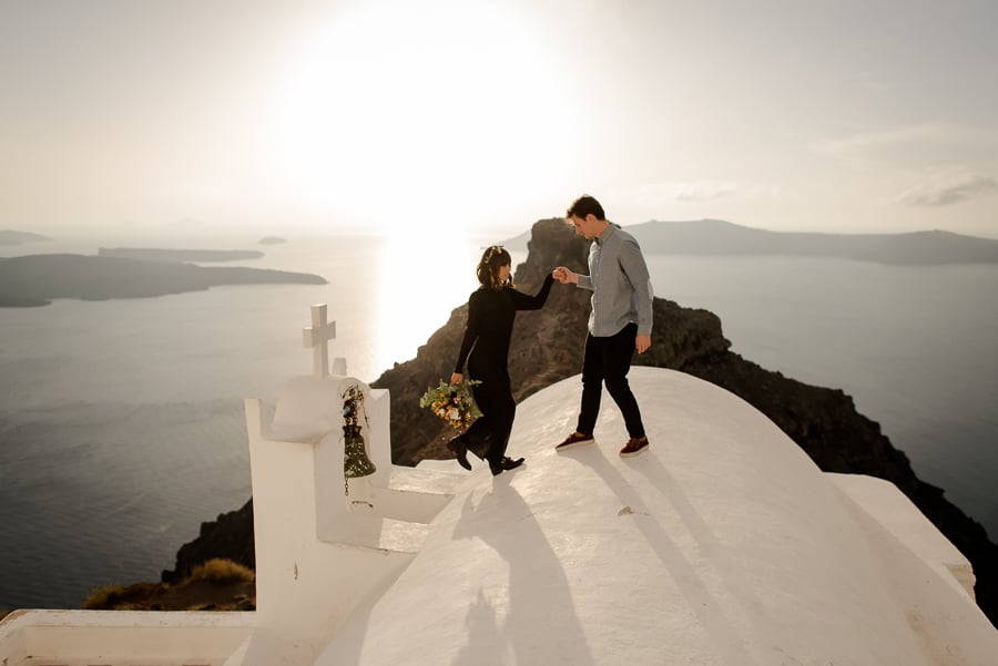 engaged coupleon the roof of a church with skaros rock view