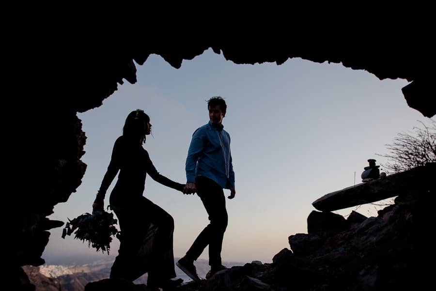 couple walking skaros rock cave