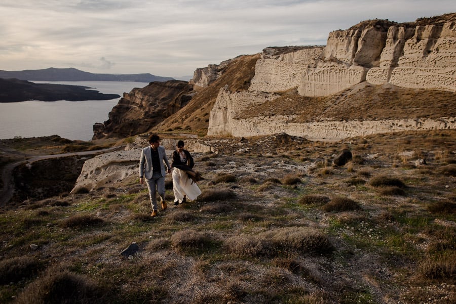 bride and groom walking santorini wedding