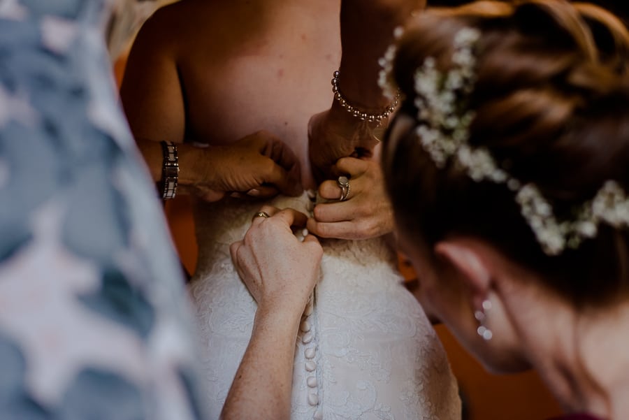 Bride is dressing her wedding dress