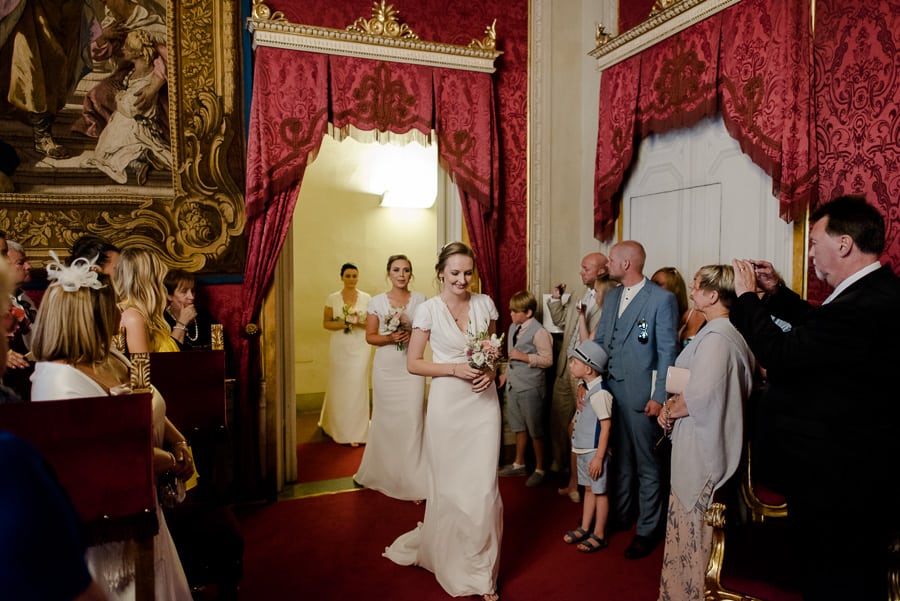 Bridesmaids are entering in the red hall at palazzo vecchio florence