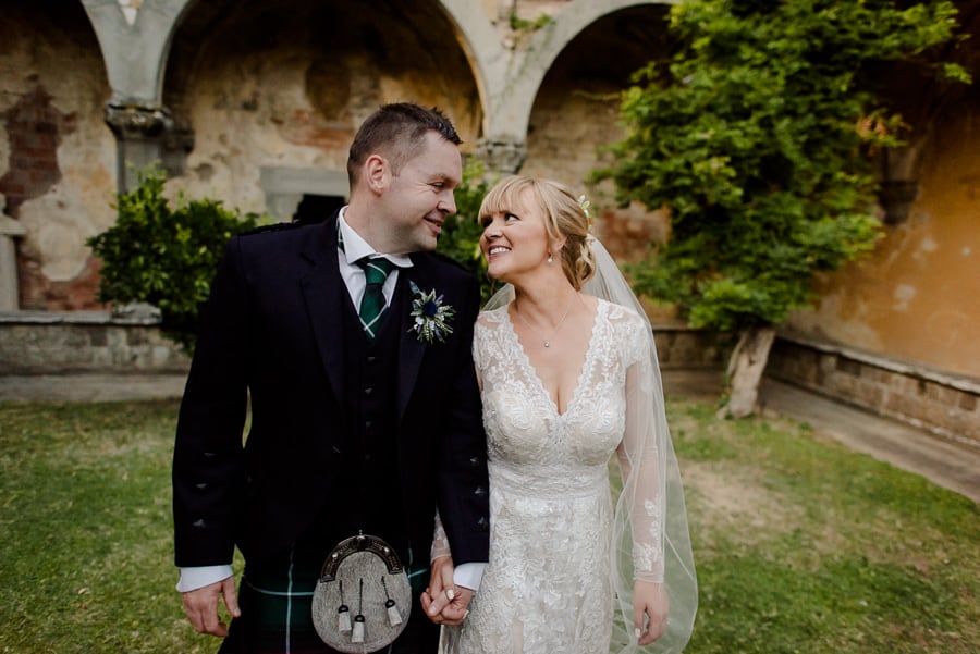 bride and groom walking and laughing at vincigliata castle florence