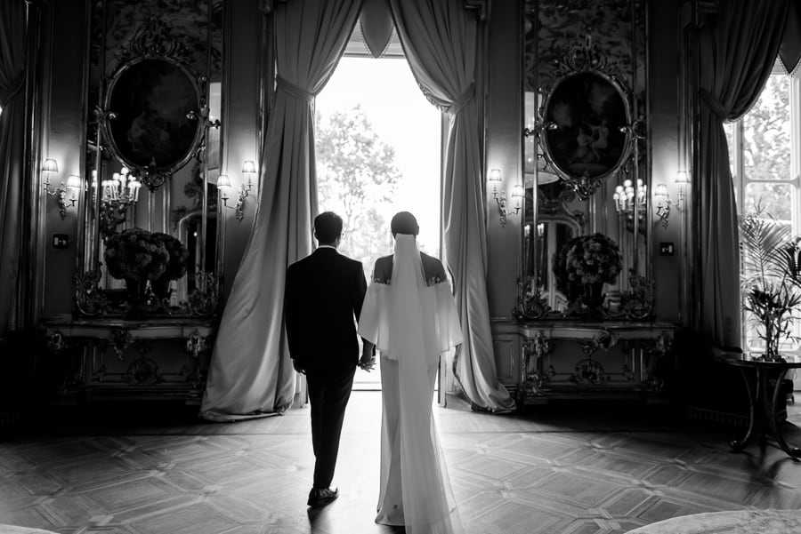 Bride and groom wlaking together inside the great hall in villa cora