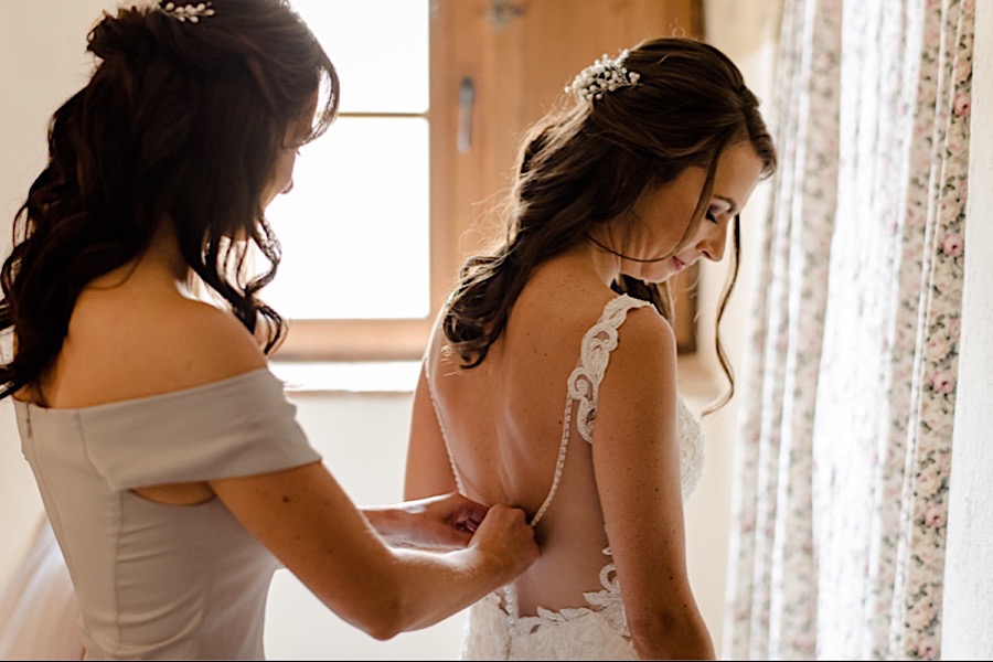 Bride getting ready wearing her dress