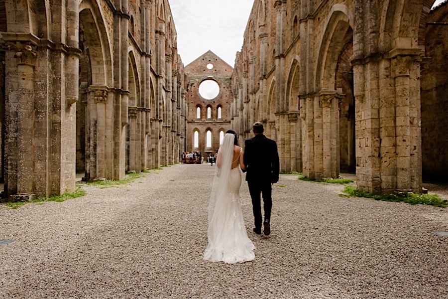 Bride walking with father down the aisle at San Galgano abbey