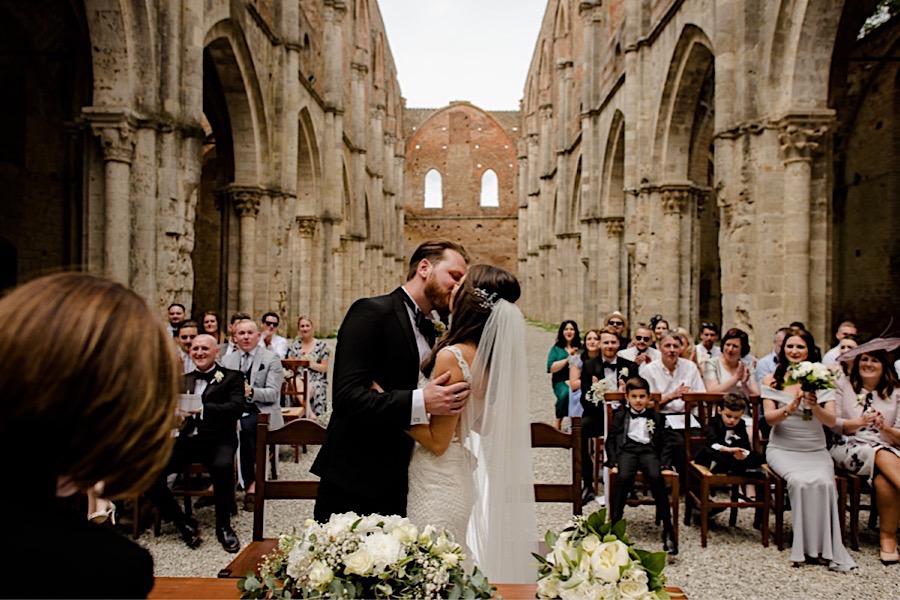 Bride and groom kissing each other during the ceremony at san galgano abbey