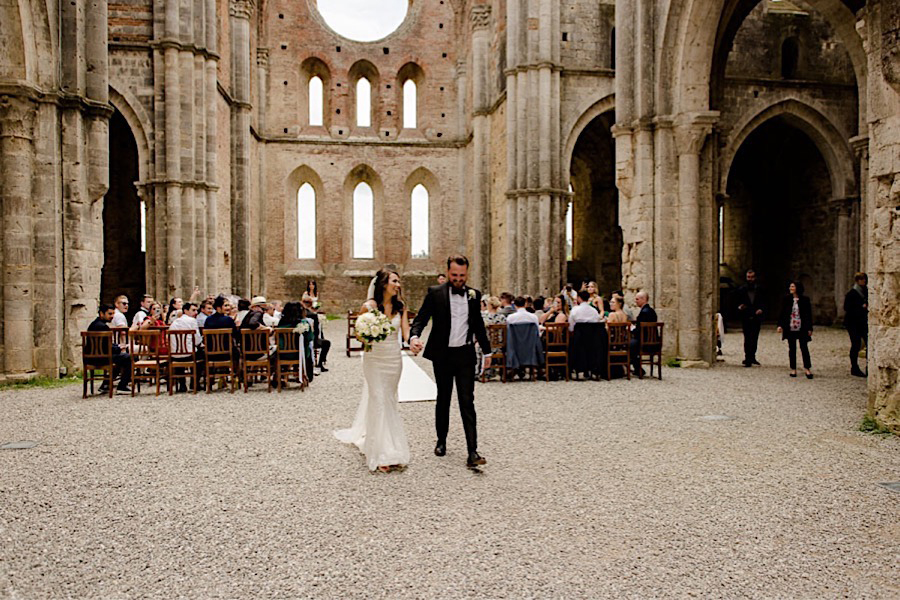 Bride and groom walking together after the wedding ceremony at san galgano abbey