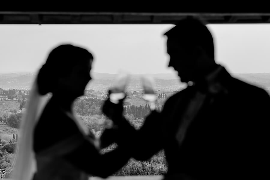 Newlywed couple having a toast with a panoramic view of Florence at Villa Le Fontanelle Black and White photo