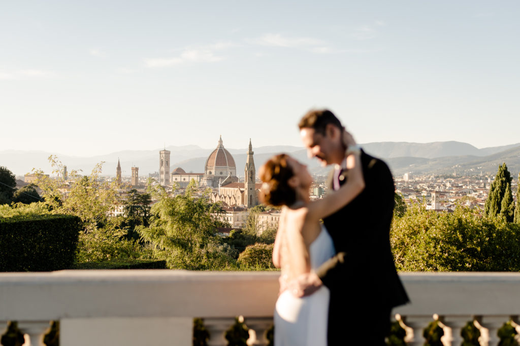 Romantic wedding couple kissing with the view of florence in the background