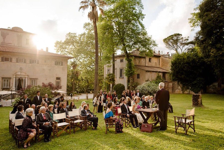 Wedding ceremony outdoor in a garden of a villa during the golden hour.
