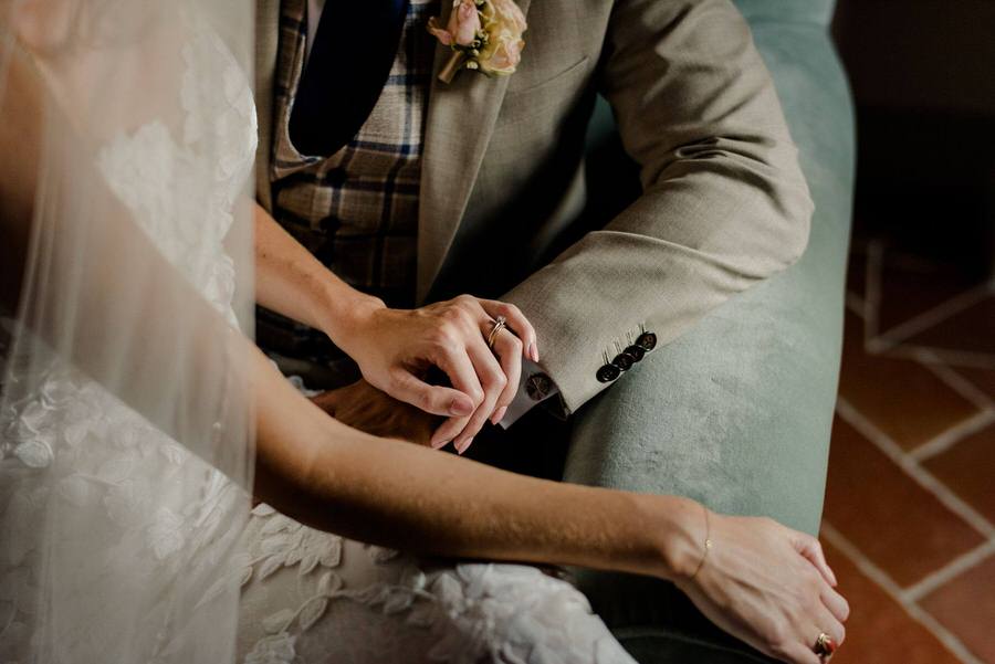 details of a wedding couple holding their hands