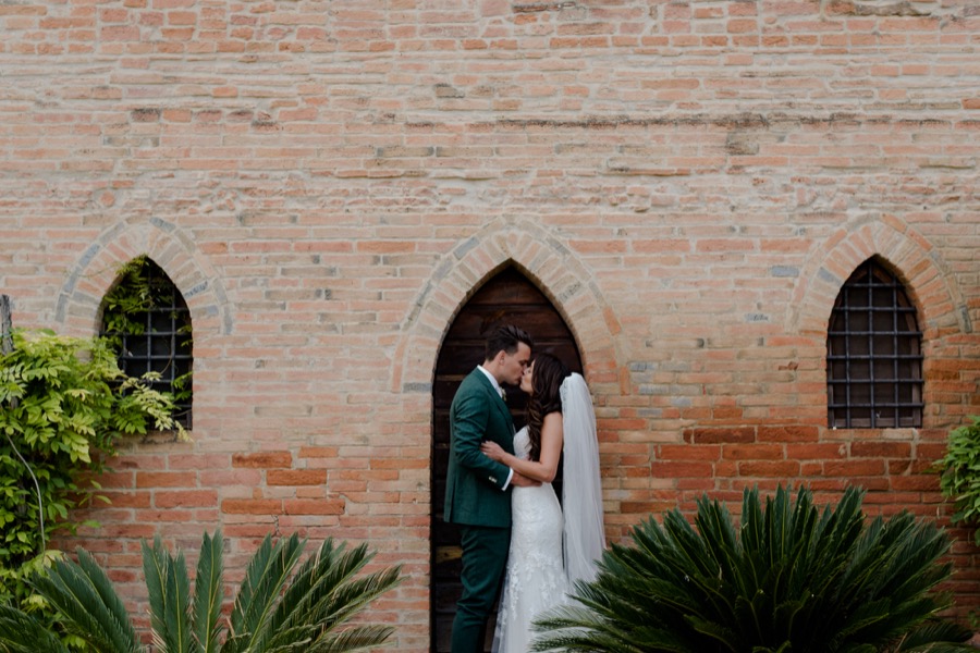 Bride and groom kissing each other at Tenuta di Pratello Country Resort