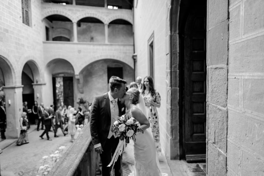 bride and groom kissing at montegufoni castle black and white