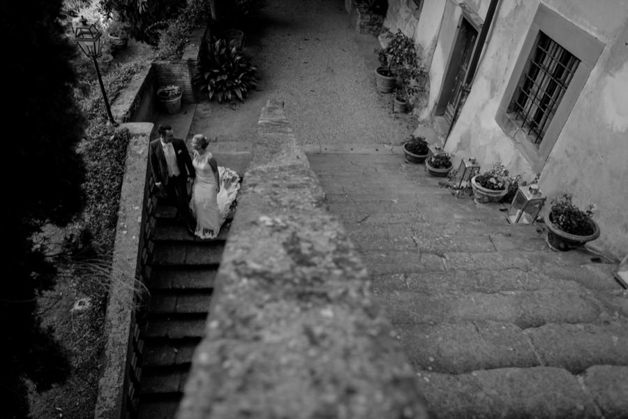 wedding couple walking down the stairs at montegufoni castle