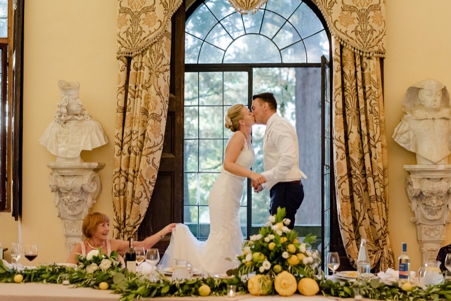 bride and groom stand on the chairs and kissing