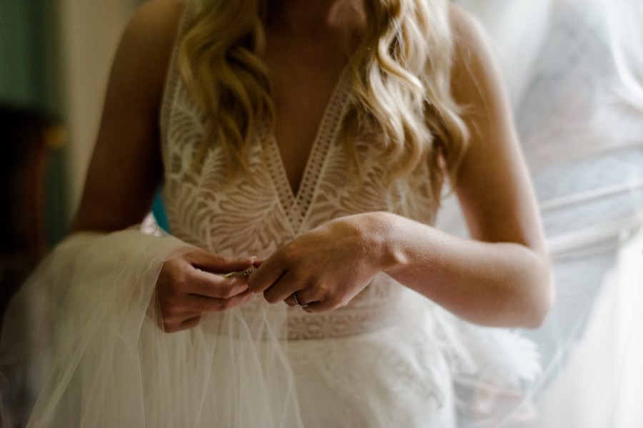 Hands details of the bride with her wedding dress