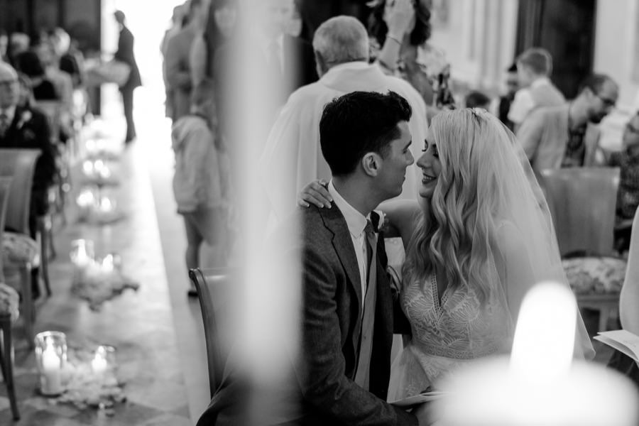 candid moment of the bride and groom kissing each other during the wedding ceremony