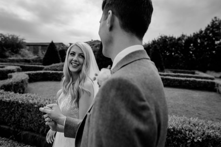 bride and groom walkins together black and white photo