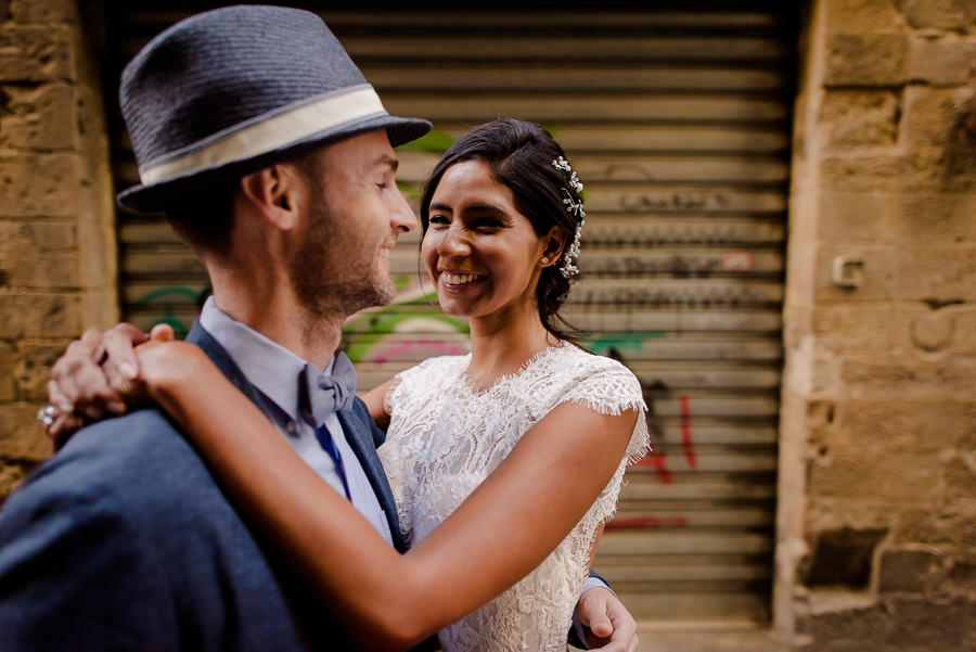 bride is amiling and embracing his groom