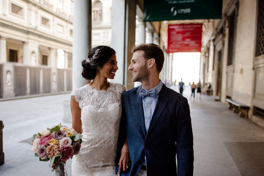 wedding couple walking under the uffizi in florence