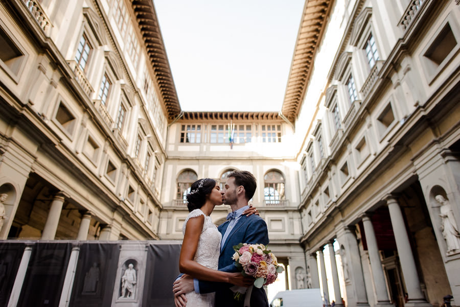 bride and groom kissing in florence with the uffizi building as backdrop