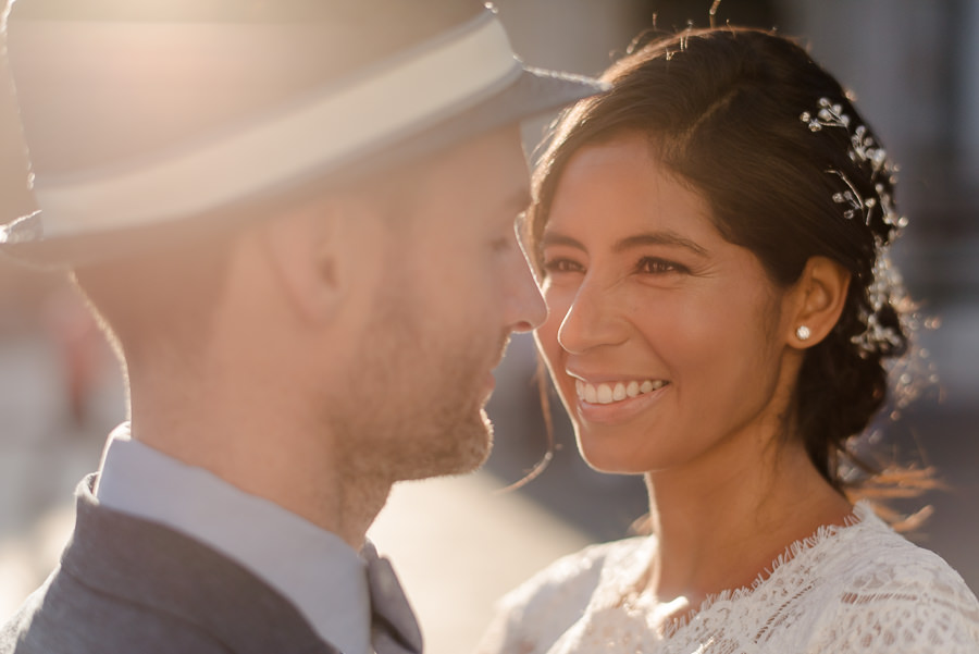 bride smiling with the groom and a warm light