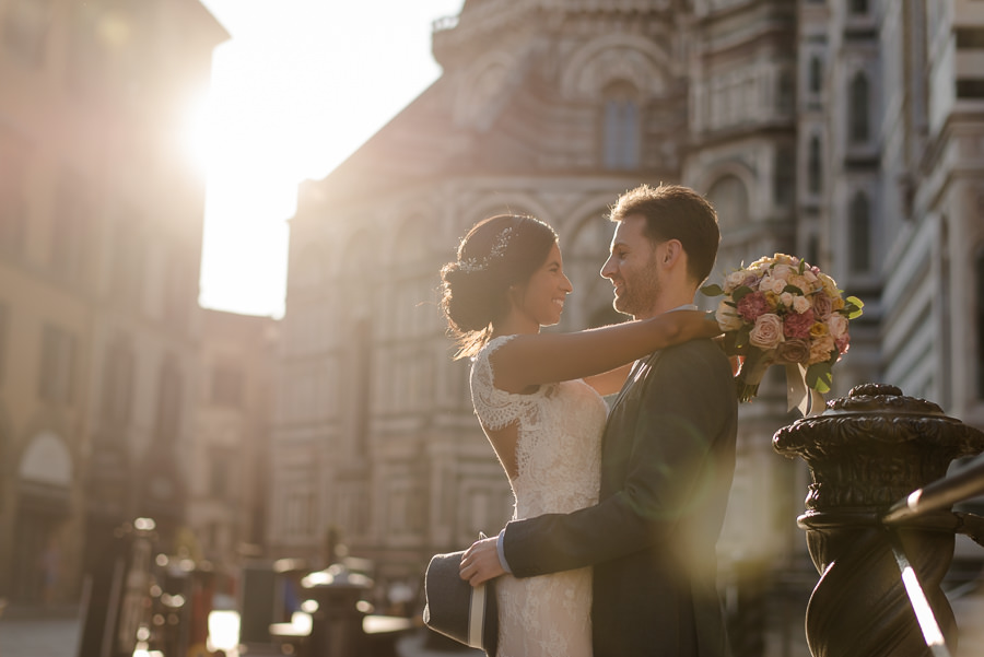 bride and groom embracing each other with t warm light in florence