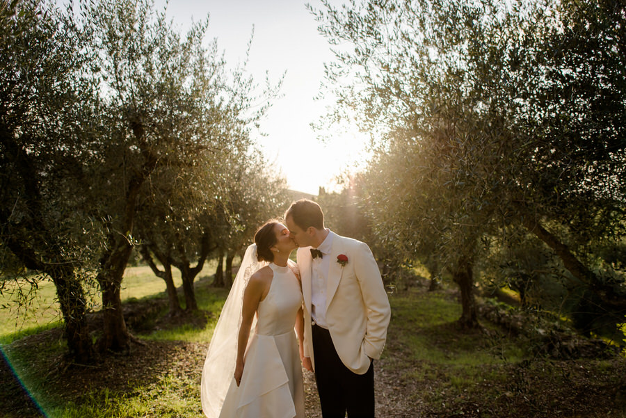 bride and groom walking in a olive trees road during the golden hour