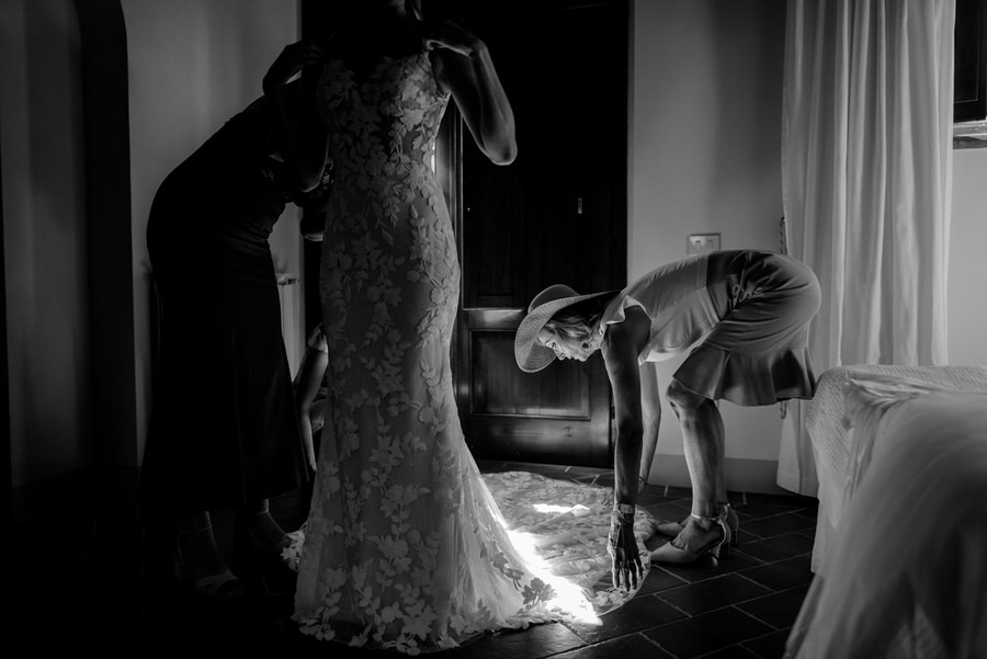 mother helping his daughter to wear the bridal dress