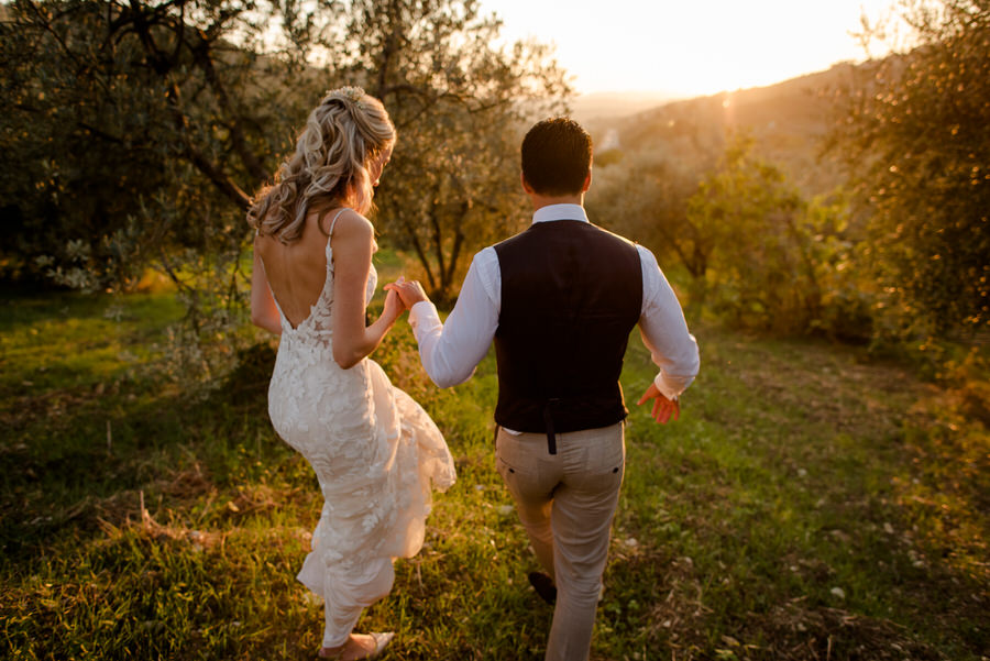 wedding couple walking seen from behind in tuscany at Borgo i Vicelli Florence during the golden hour