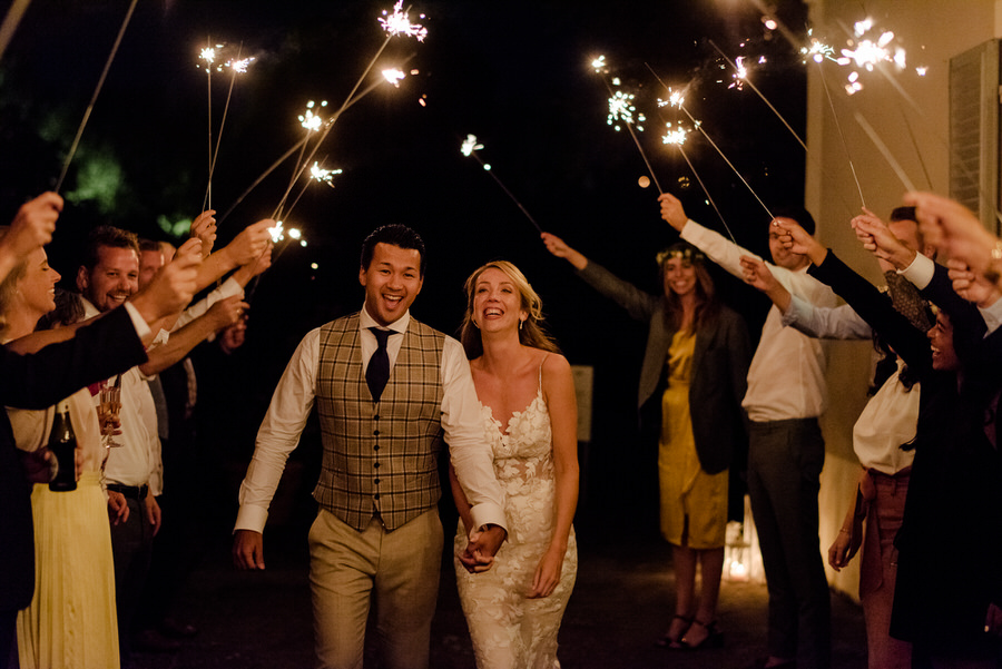 wedding couple walking thru the sparkling lights