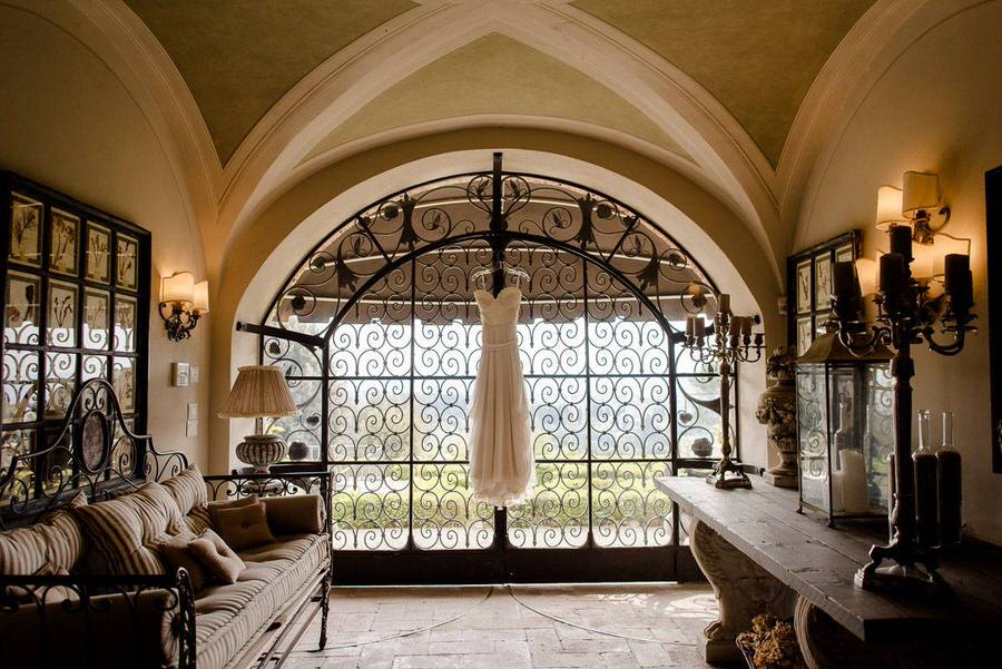 bridal dress hanged at the top of a ancient door at villa Fontanelle in Florence