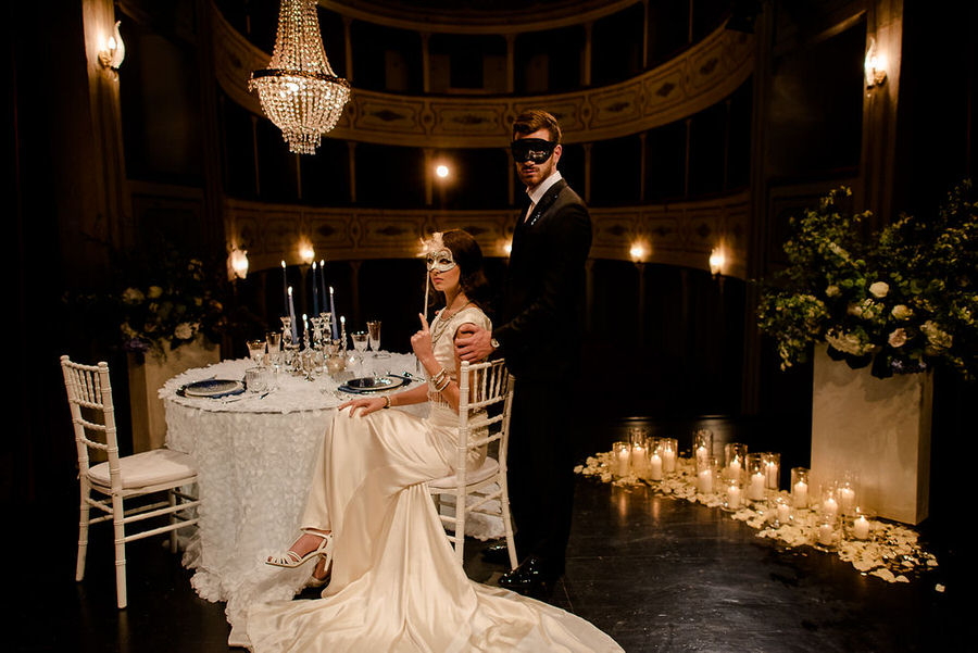 wedding table in a theather bride and groom with theatrical masks